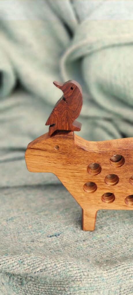 A wooden Cayú bird toy capybara