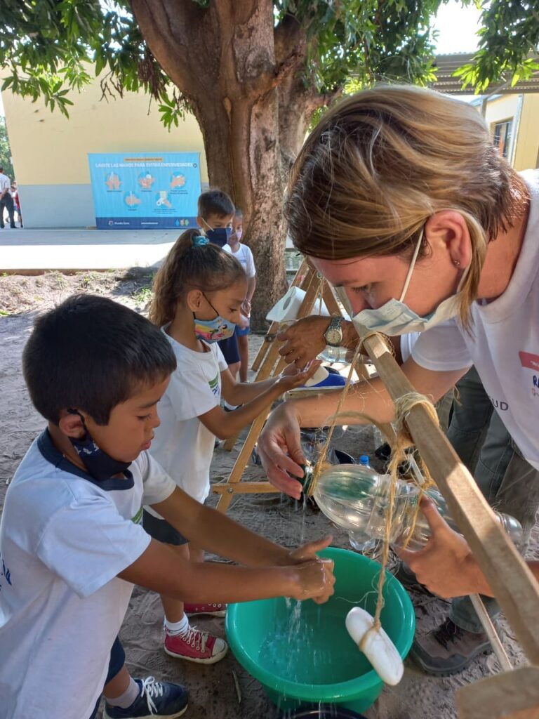 Children washing their hands with the Tippy Tap