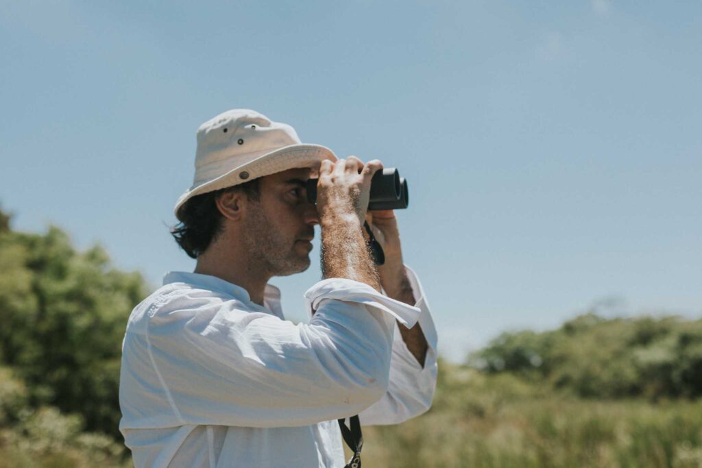 Persona usando binoculares en paisaje turístico argentino